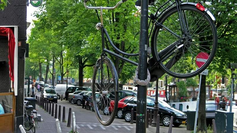 A bicycle parked beside an Amsterdam street